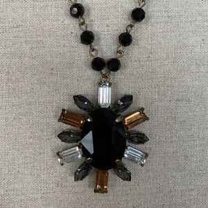 Long black and gold starburst necklace
